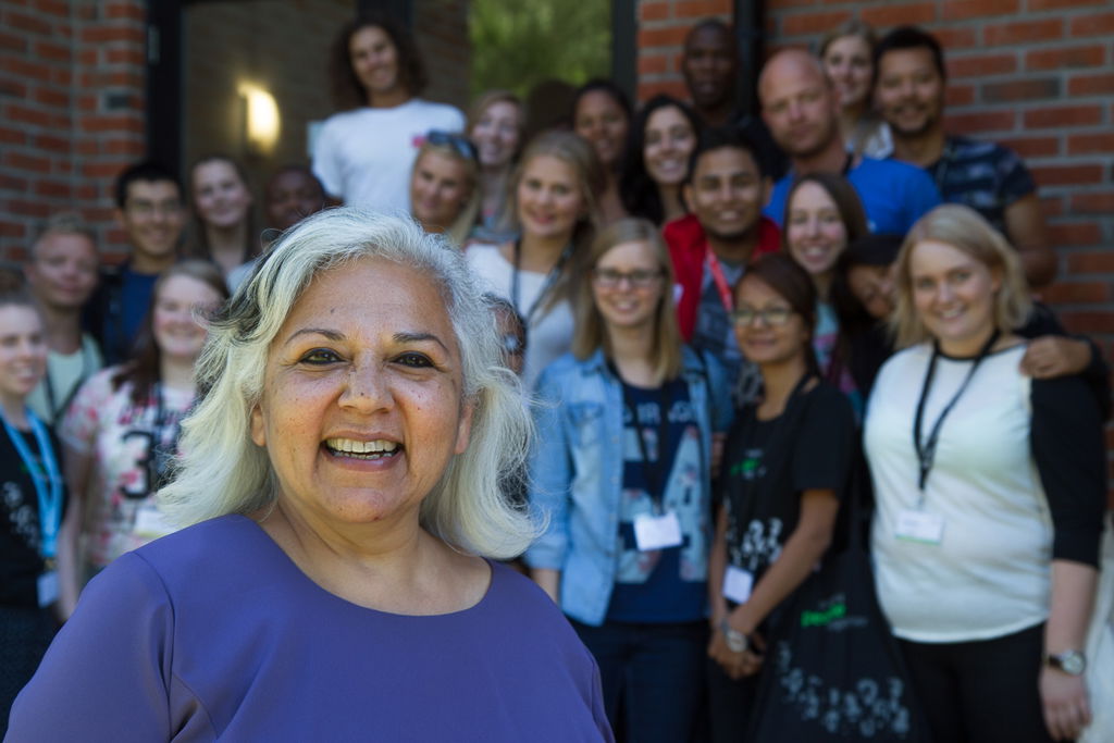 Tidligere direktør i Fredskorpset Nita Kapoor poserer foran en gruppe unge mennesker som skal på utveksling. Bildet er tatt i 2017.