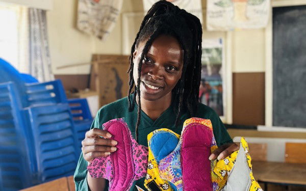 Picture of Madalo Nyirongo holding the menstrual products.